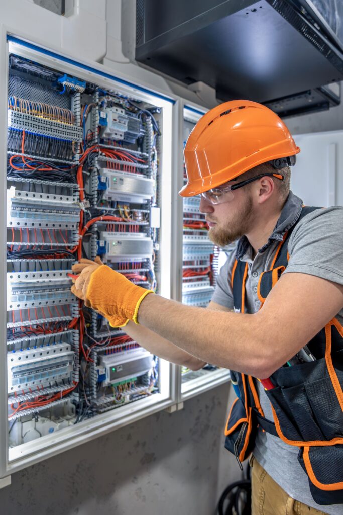Industrial electrician fixing an issue in large electrical panel